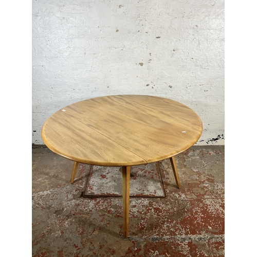 136 - A mid 20th century Ercol blonde elm and beech Windsor drop leaf oval dining table