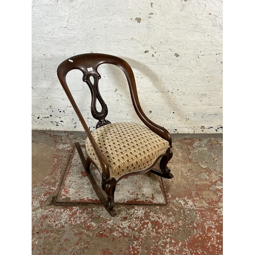 137 - A Victorian carved mahogany and floral fabric upholstered rocking chair