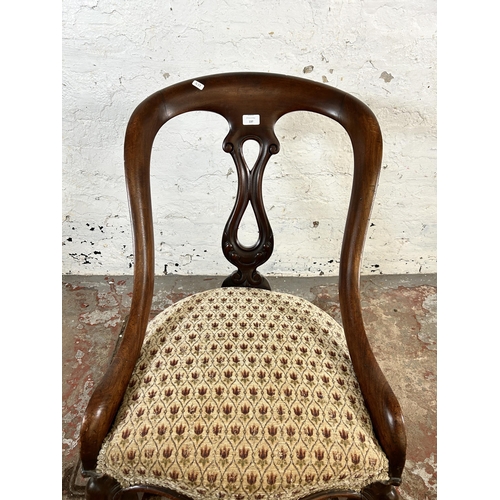 137 - A Victorian carved mahogany and floral fabric upholstered rocking chair