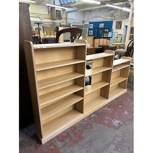 153 - A modern beech three section graduating bookcase - approx. 137cm high x 238cm wide x 23cm deep