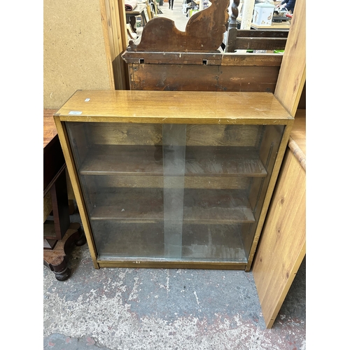 174 - A mid 20th century Phoenix walnut bookcase with two glass sliding doors