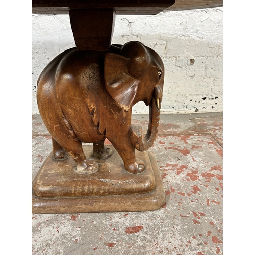 202 - A carved hardwood elephant design pedestal side table - approx. 48cm high x 60cm wide x 70cm deep