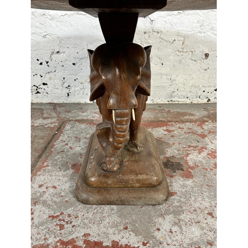 202 - A carved hardwood elephant design pedestal side table - approx. 48cm high x 60cm wide x 70cm deep