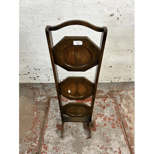 204 - An early 20th century oak three tier folding cake stand - approx. 91cm high