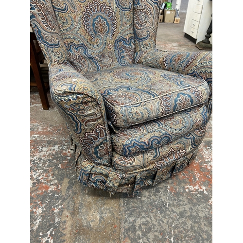 224 - A mid 20th century fabric upholstered paisley wing back armchair