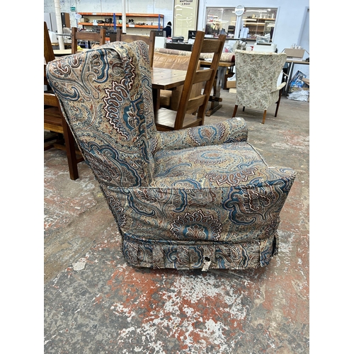 224 - A mid 20th century fabric upholstered paisley wing back armchair