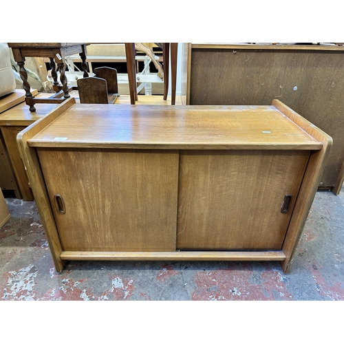 73 - A mid 20th century teak two door record cabinet - approx. 58cm high x 92cm wide x 48cm deep