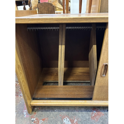 73 - A mid 20th century teak two door record cabinet - approx. 58cm high x 92cm wide x 48cm deep