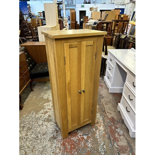 92 - A modern oak two door cabinet - approx. 116cm high x 50cm wide x 33cm deep