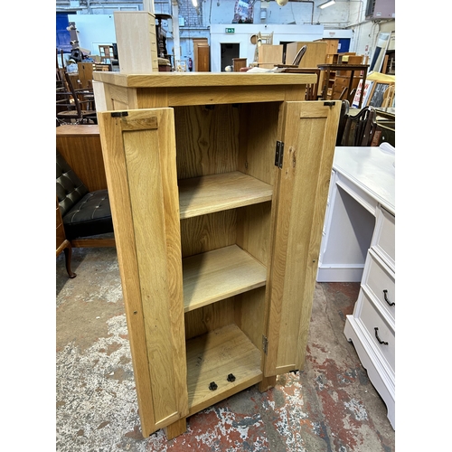 92 - A modern oak two door cabinet - approx. 116cm high x 50cm wide x 33cm deep