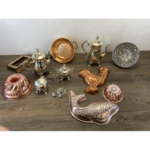 373 - A collection of metalware to include Victorian style copper jelly moulds, early 20th century oak and... 