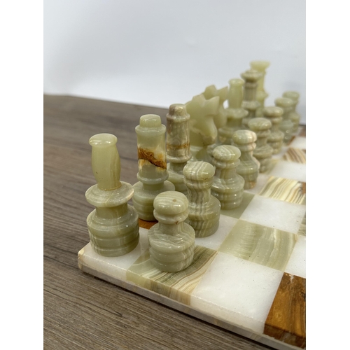 397 - A marble and onyx chess set - board approx. 31cm square