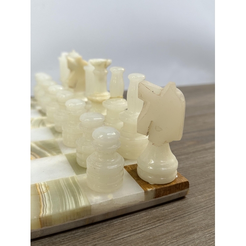 397 - A marble and onyx chess set - board approx. 31cm square