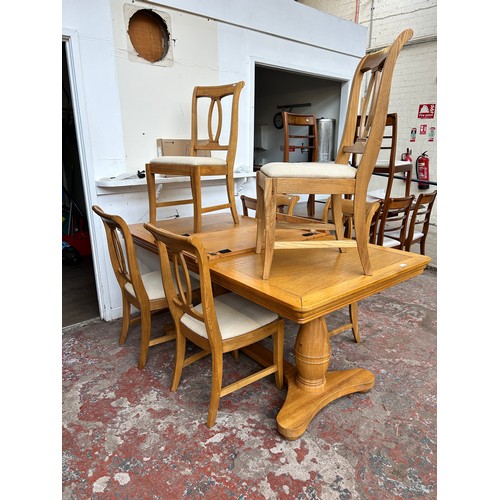 75A - A modern oak twin pedestal extending dining table and six chairs - approx. 78cm high x 100cm wide x ... 