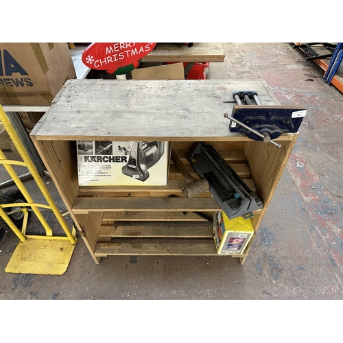 789 - A pine two tier shelving unit with mounted bench vice and contents to include boxed Kärcher K25e pow... 