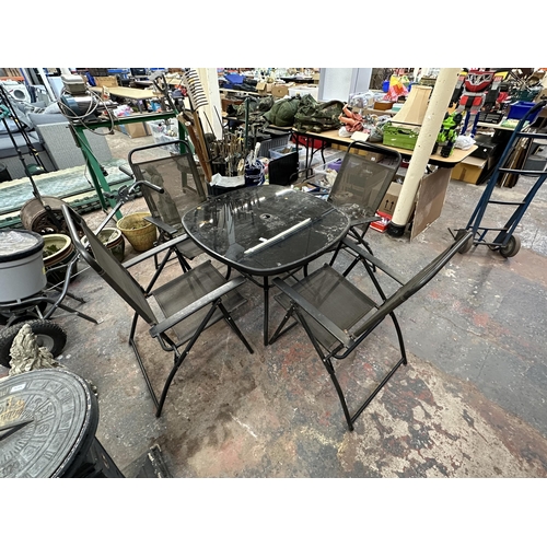 803 - A black metal five piece patio set comprising glass top table and four chairs - table approx. 70cm h... 