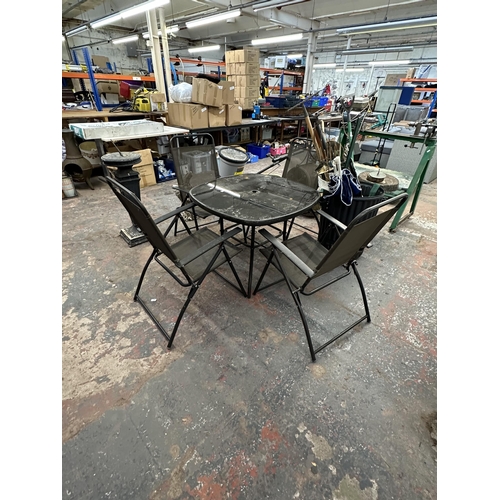 803 - A black metal five piece patio set comprising glass top table and four chairs - table approx. 70cm h... 