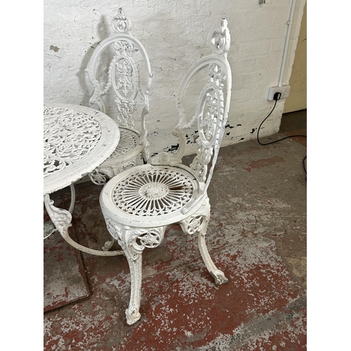 816 - A Victorian style white painted cast metal five piece patio set comprising circular table and four c... 