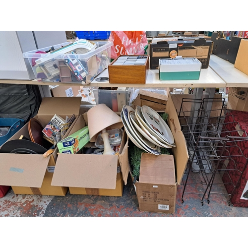 836 - A large collection of house clearance items to include two wired metal bottle racks, ceramic meat pl... 