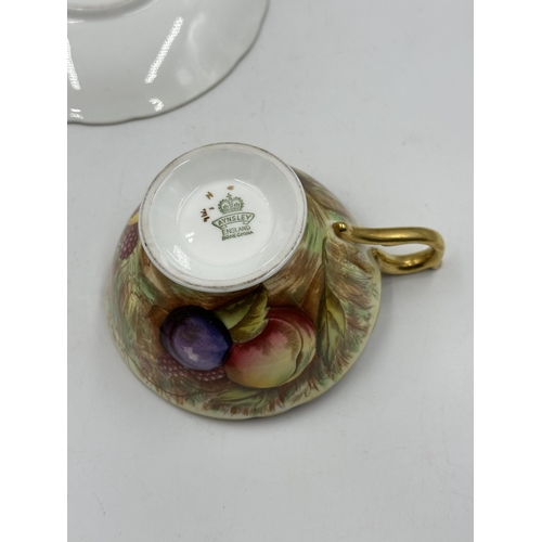 317 - An Aynsley Orchard Gold bone china tea cup and saucer signed N.Brunt