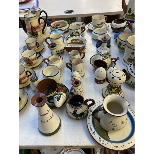 332 - A collection of mottoware pottery to include Watcombe Torquay etc.