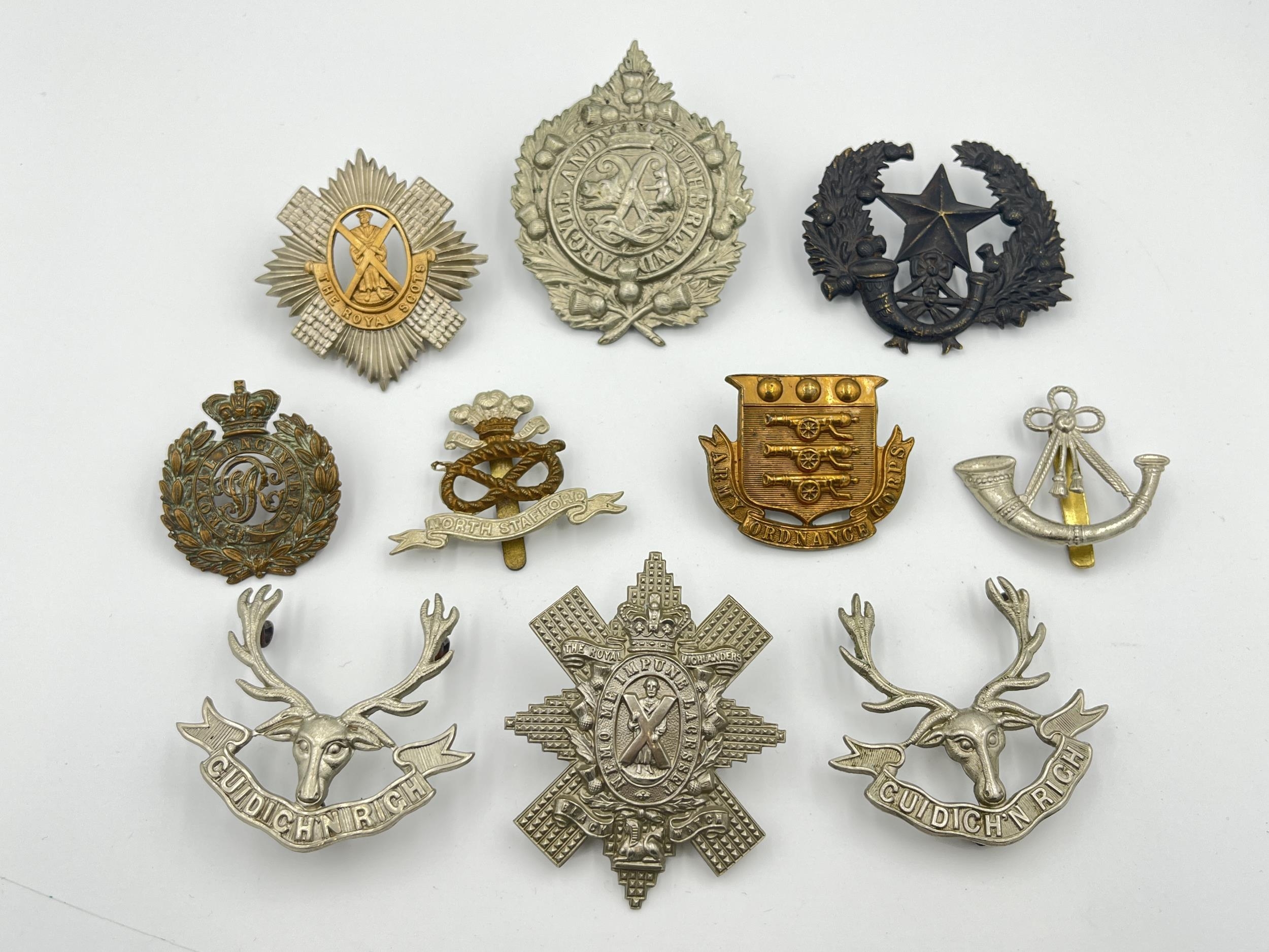 Ten military cap badges
