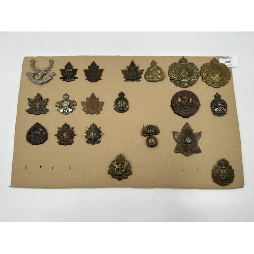 2297 - A collection of military cap badges