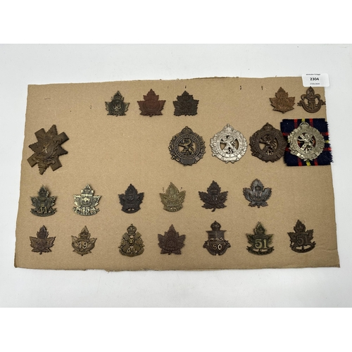 2304 - A collection of military cap badges