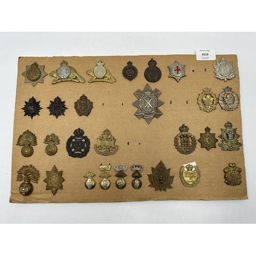 2319 - A collection of military cap badges