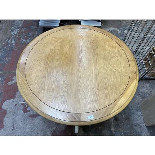 20 - A modern oak and white painted circular pedestal dining table - approx. 75cm high x 103cm diameter