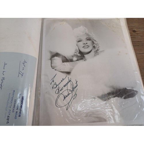 671 - Two folders containing signed items to include Frank Sinatra, Mae West, Peter Cushing, Peggy Mount, ... 