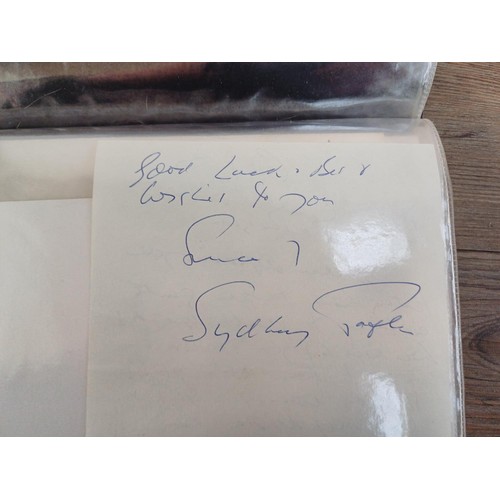 671 - Two folders containing signed items to include Frank Sinatra, Mae West, Peter Cushing, Peggy Mount, ... 