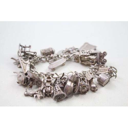 2442 - A silver charm bracelet with assorted charms - approx. gross weight 87g