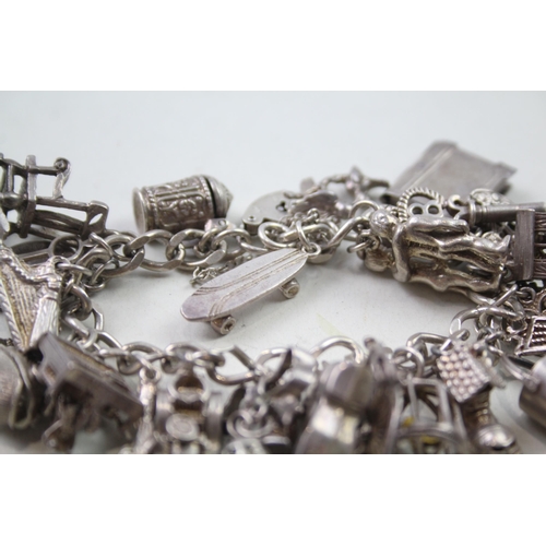 2442 - A silver charm bracelet with assorted charms - approx. gross weight 87g