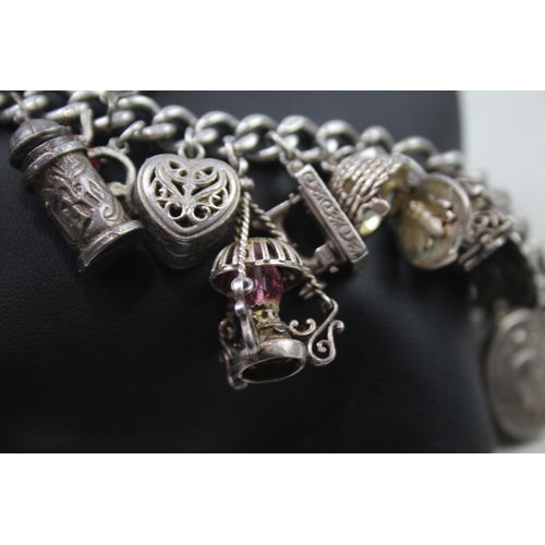 2468 - A silver charm bracelet with assorted charms - approx. gross weight 99g