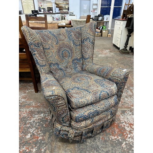 255 - A mid 20th century paisley fabric upholstered wing back armchair