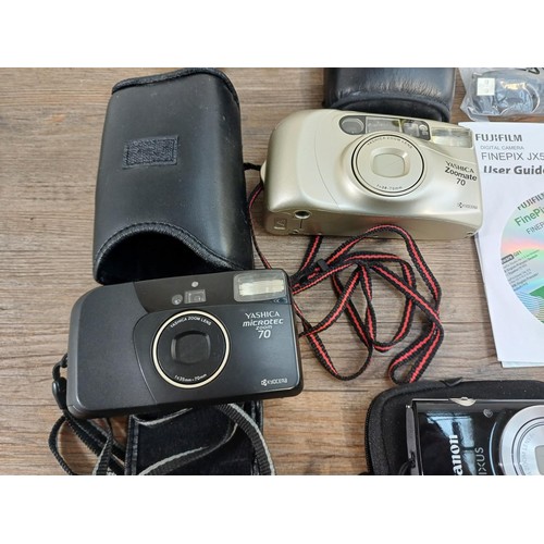 593 - A collection of cameras to include boxed Fujifilm JX530 14mp compact digital with accessories, charg... 