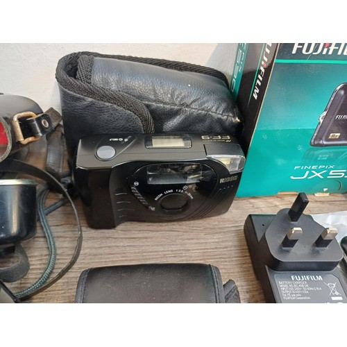 593 - A collection of cameras to include boxed Fujifilm JX530 14mp compact digital with accessories, charg... 