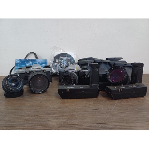 605 - A collection of Olympus items to include two OM10 35mm SLR cameras, nine cased T20 flashes, two OM W... 