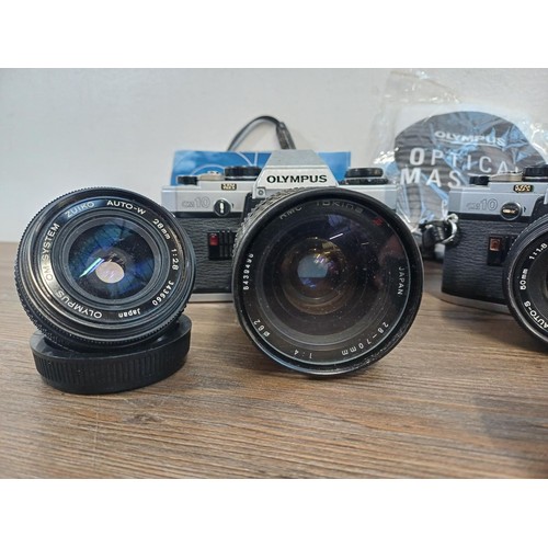 605 - A collection of Olympus items to include two OM10 35mm SLR cameras, nine cased T20 flashes, two OM W... 