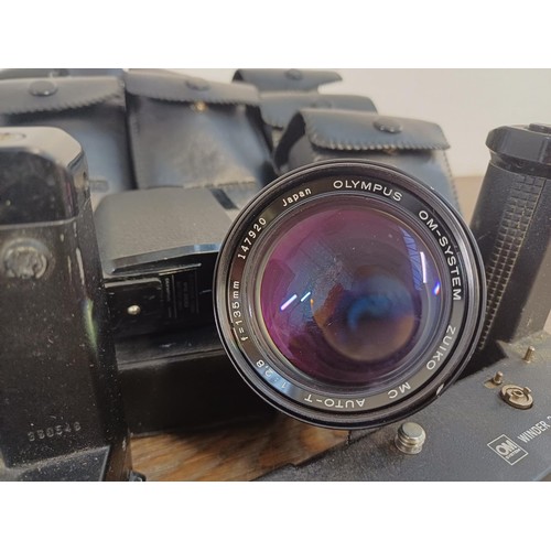 605 - A collection of Olympus items to include two OM10 35mm SLR cameras, nine cased T20 flashes, two OM W... 