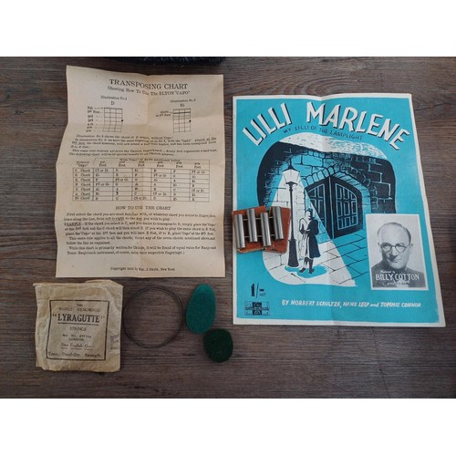 800B - A cased mid 20th century soprano ukulele with 'Lilli Marlene' single sheet, boxed pitch pipe, felt p... 