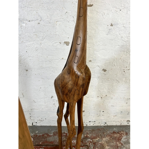 218 - Two carved hardwood statues, one giraffe - approx. 150cm high and one lady - approx. 173cm high