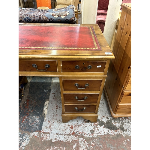 235 - A yew wood and red leather pedestal writing desk - approx. 78cm high x 122cm wide x 60cm deep