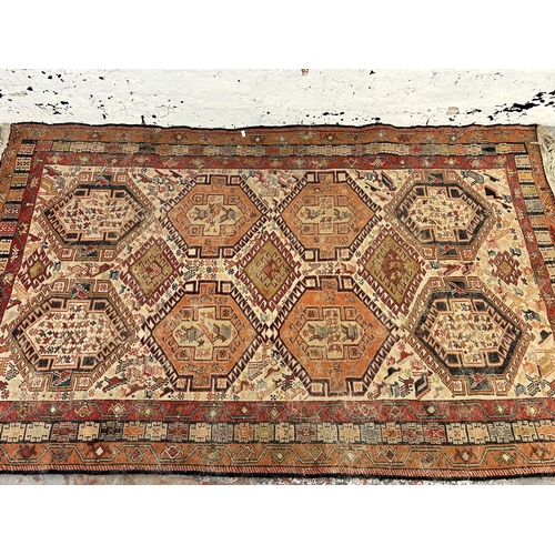 242 - An antique hand knotted rug - approx. 196cm x 118cm wide