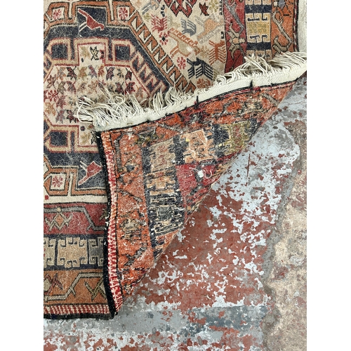 242 - An antique hand knotted rug - approx. 196cm x 118cm wide