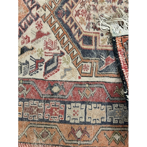 242 - An antique hand knotted rug - approx. 196cm x 118cm wide