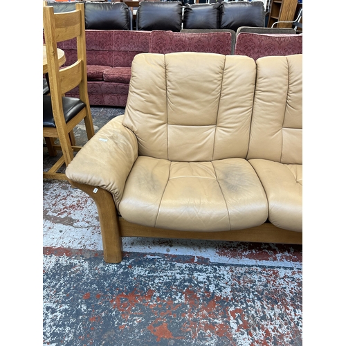 260 - An Ekornes Stressless tan leather and beech reclining two seater sofa - approx. 88cm high x 164cm wi... 