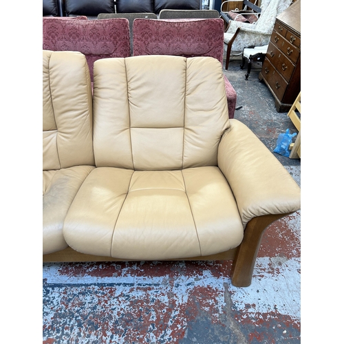 260 - An Ekornes Stressless tan leather and beech reclining two seater sofa - approx. 88cm high x 164cm wi... 