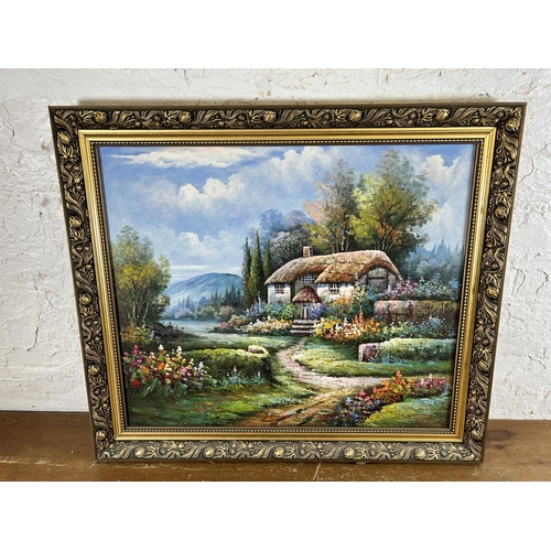 277 - A 20th century gilt framed oil on board of a cottage scene - approx. 61cm high x 71cm wide